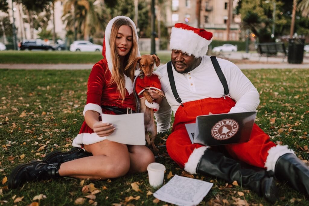 people and dog in santa costume sitting in the park